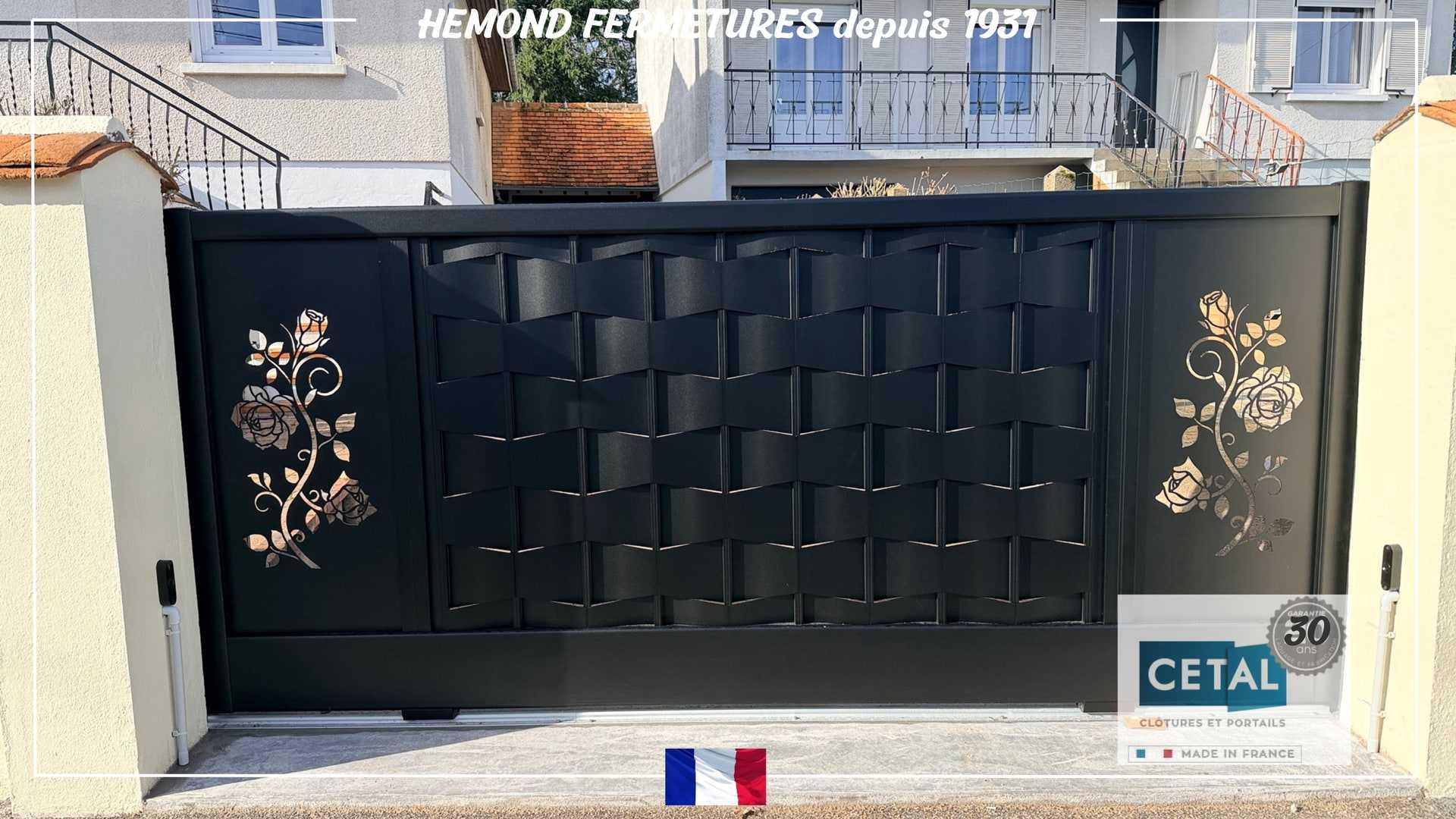 Portail coulissant noir orné de motifs floraux, installé par Hemond Fermetures